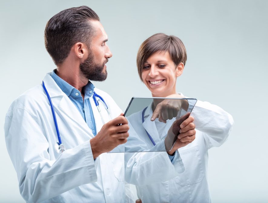 Medical team examines patient data on a transparent device, showcasing integration of AI in healthcare